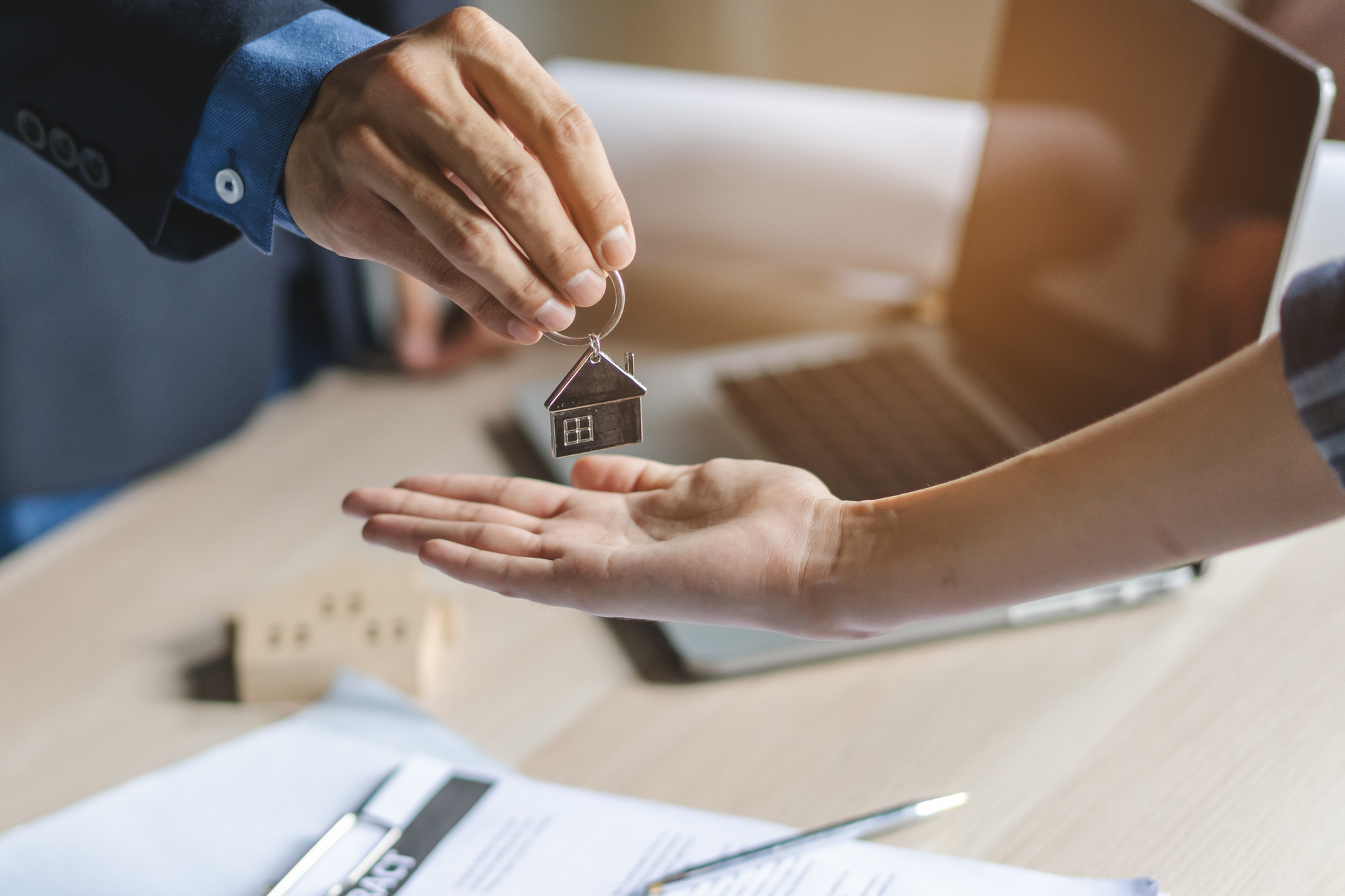 A man hands a house key to a woman